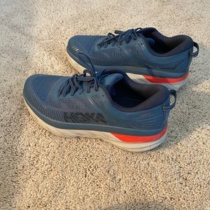 Blue HOKA athletic shoes.